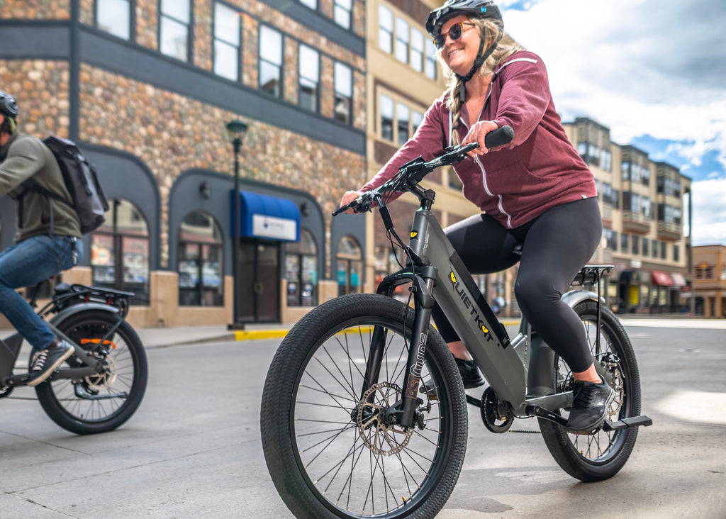 Une femme pratique la sécurité du vélo électrique en portant son casque pendant la conduite.