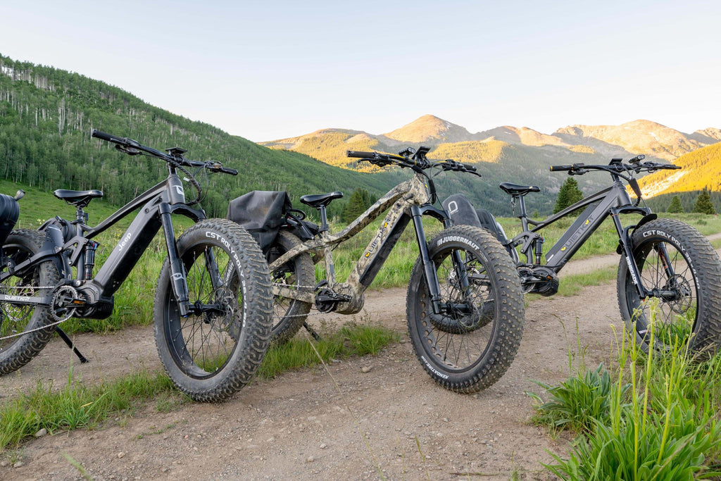 Trois vélos électriques QuietKat sur un chemin de terre