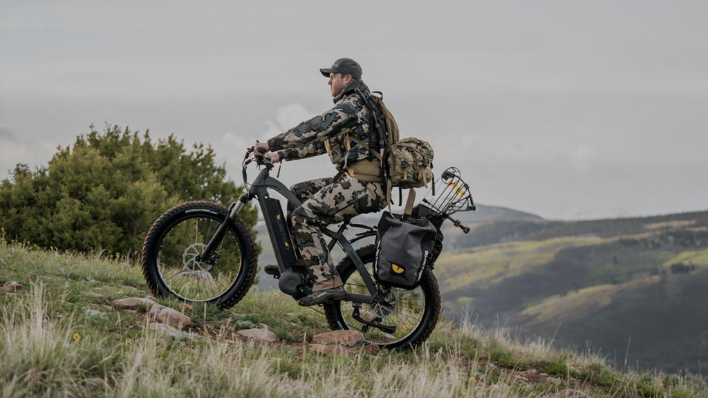 Un chasseur chevauche son vélo électrique QuietKat sur une colline escarpée.