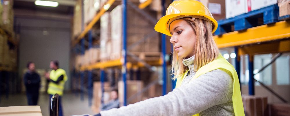 female working in warehouse wearing women-specific safety vests