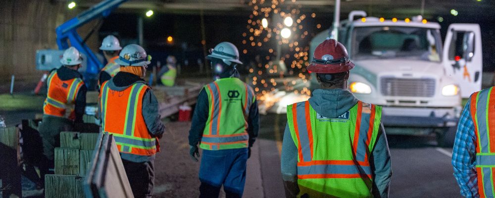 worker wearing hi-vis safety vest with contrasting tape in low-light condition