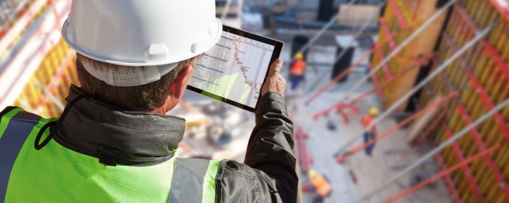 worker wearing safety vests with technology control in construction site