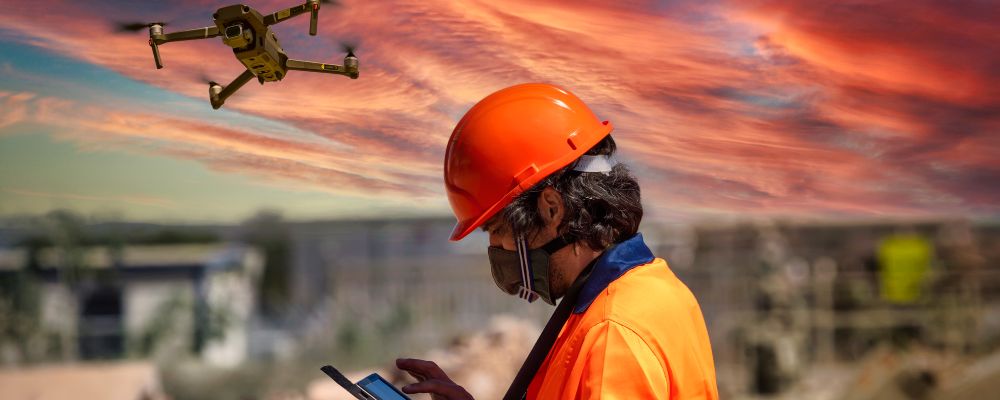 operating drone with hi-vis drone pilot safety vest and protective hard hat