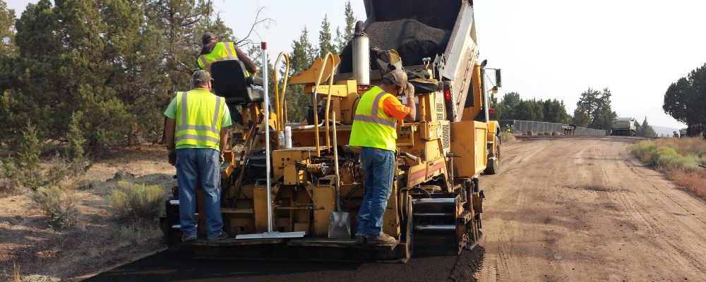 man wearing safety vest working on a road