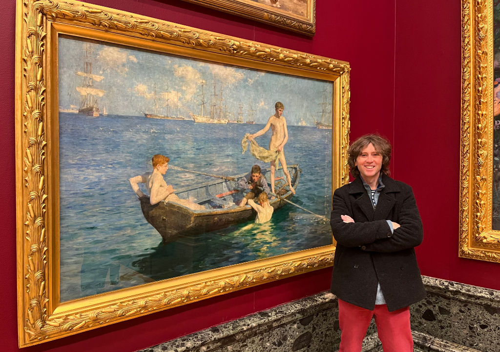 Cornish artist John Dyer standing in front of the painting 'August Blue' by Henry Scott Tuke at Tate Britain in London