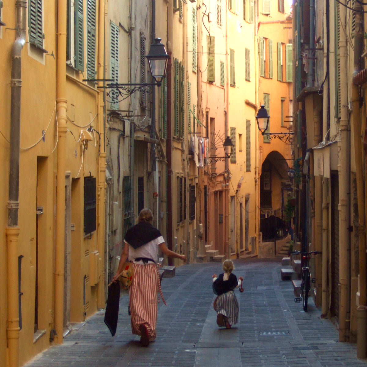 Joanne Short with her youngest daughter Wilamena walking through the Old Town of Menton dressed in traditional Mentonnaise clothes.
