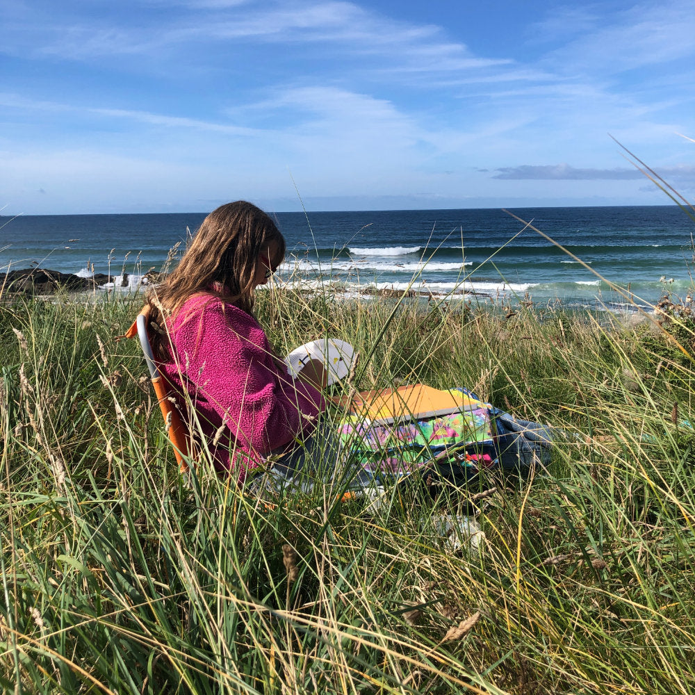 Artist Joanne Short sitting in the dunes at Gwithian, painting
