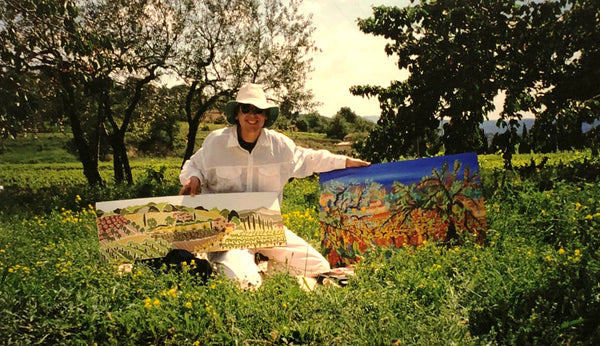 Artist John Dyer holding a painting of the French landscape by Joanne Short and one of his own paintings of Provence