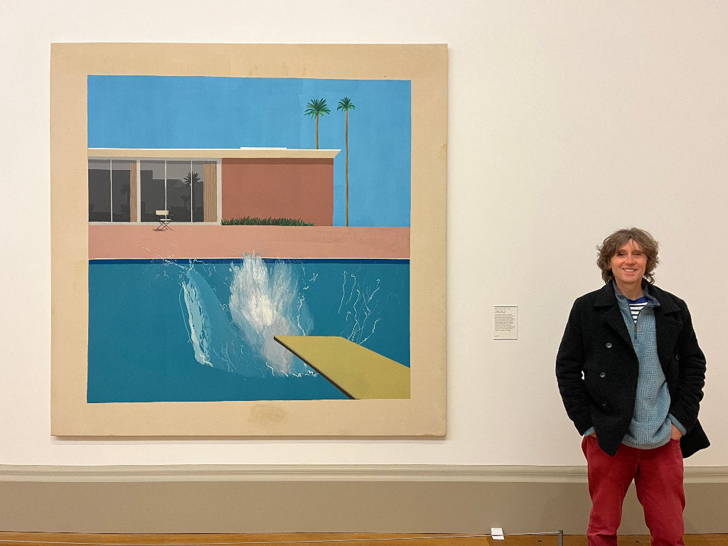 artist John Dyer standing with painting by David Hockney