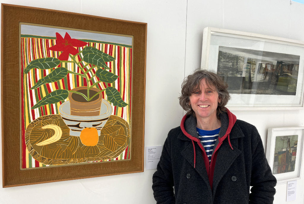 Cornish artist John Dyer pictured next to a Bryan Pearce still life painting.