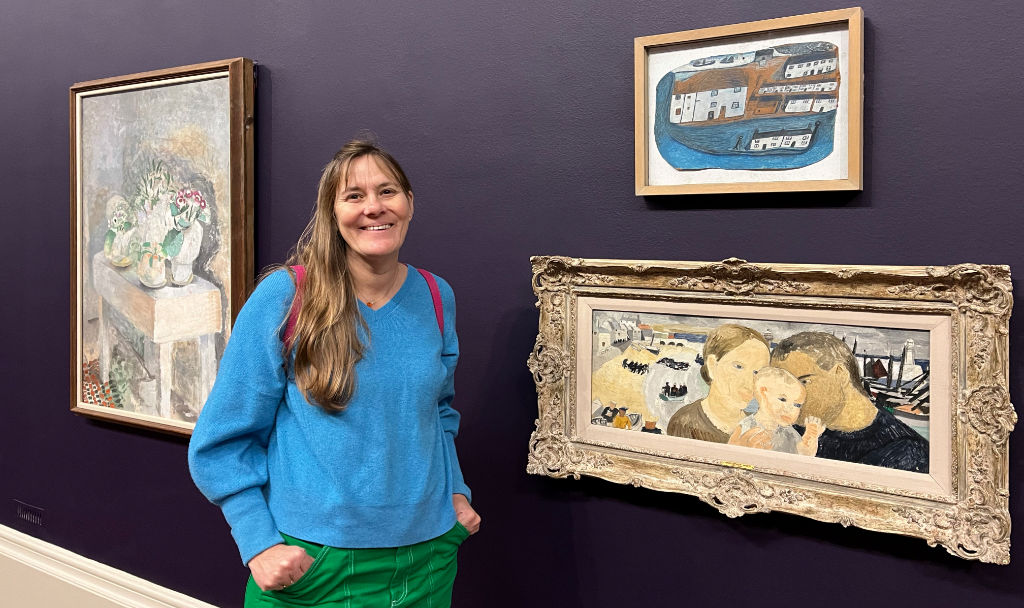 Cornish artist Joanne Short standing next to Christopher Wood and Alfred Wallis paintings at Tate Britain in London