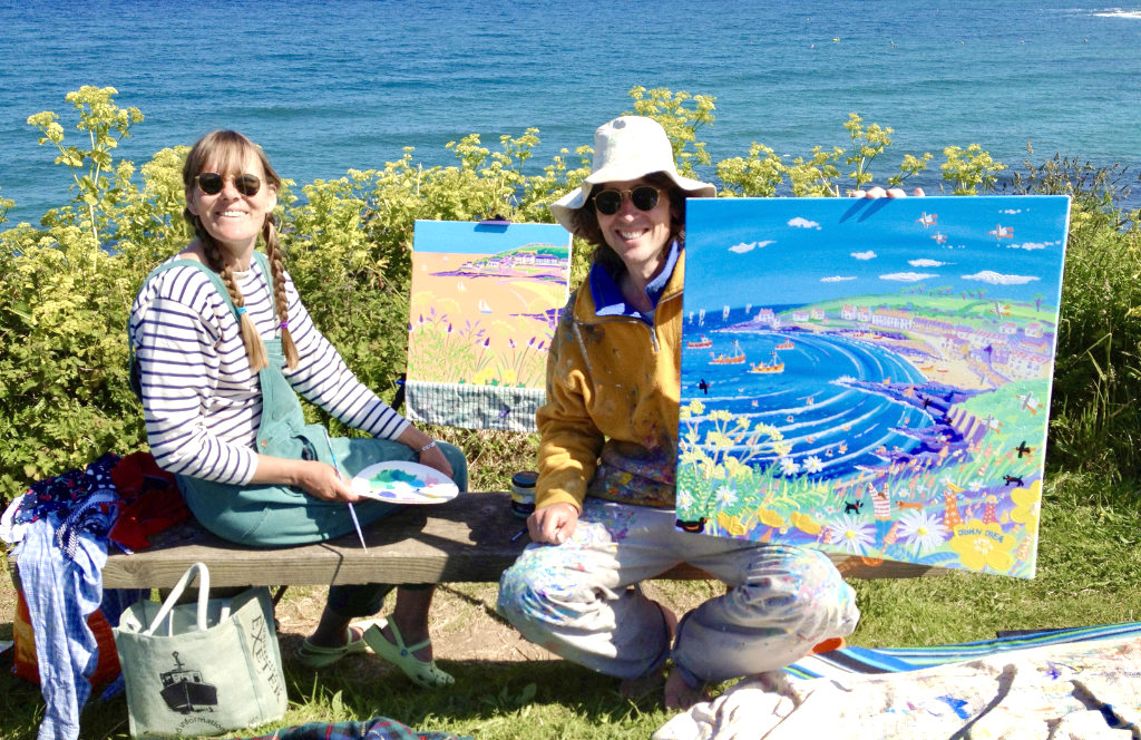 Artists Joanne Short and John Dyer pictured painting and picnicking on the cliffs at Portscatho in Cornwall