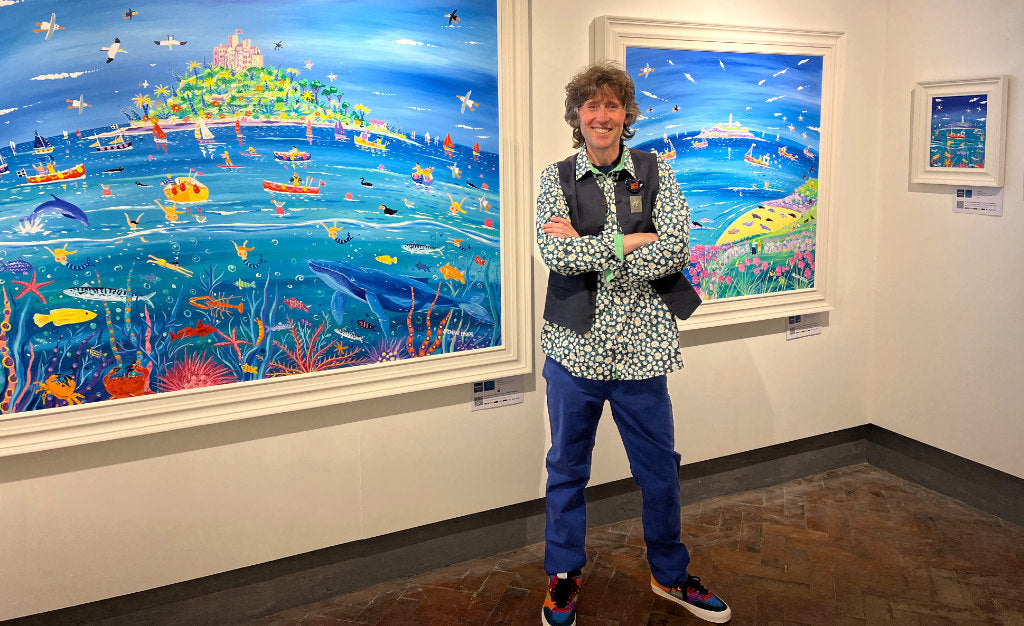 Artist John Dyer pictured with his original paintings that can be purchased online