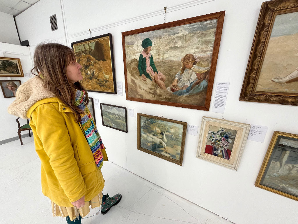 Cornish artist Joanne Short viewing a selection of pantings with investment potential at an auction house in Cornwall