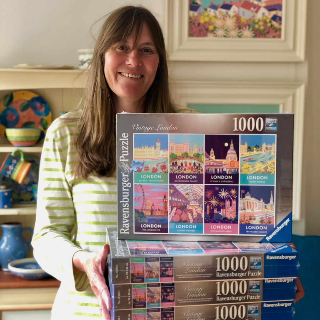 Artist Joanne Short holding her City of London Art Puzzles by Ravensburger