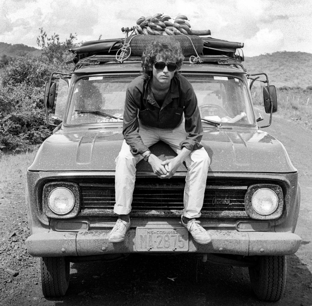 Artist John Dyer pictured sitting on a 4x4 in Brazil during his first Amazon rainforest expedition