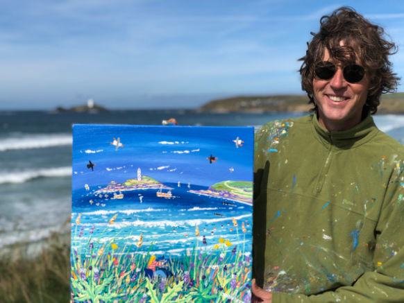 Artist John Dyer on the cliffs at Gwithian holding his painting of Godrevy lighthouse