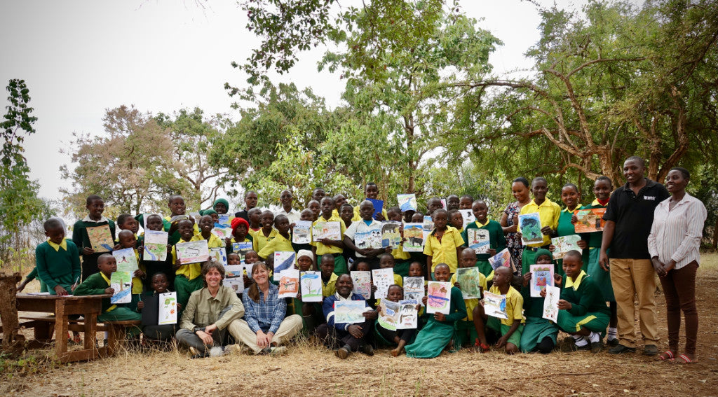 Artists John Dyer and Joanne Short pictured with a school of children in Kenya who all painted their story, their life and their wildlife for the Last Chance to Paint project.