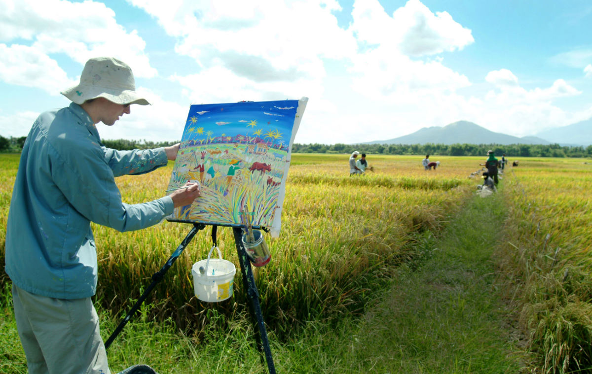 John Dyer painting the rice harvest in the Philippines for the United Nations year of Rice