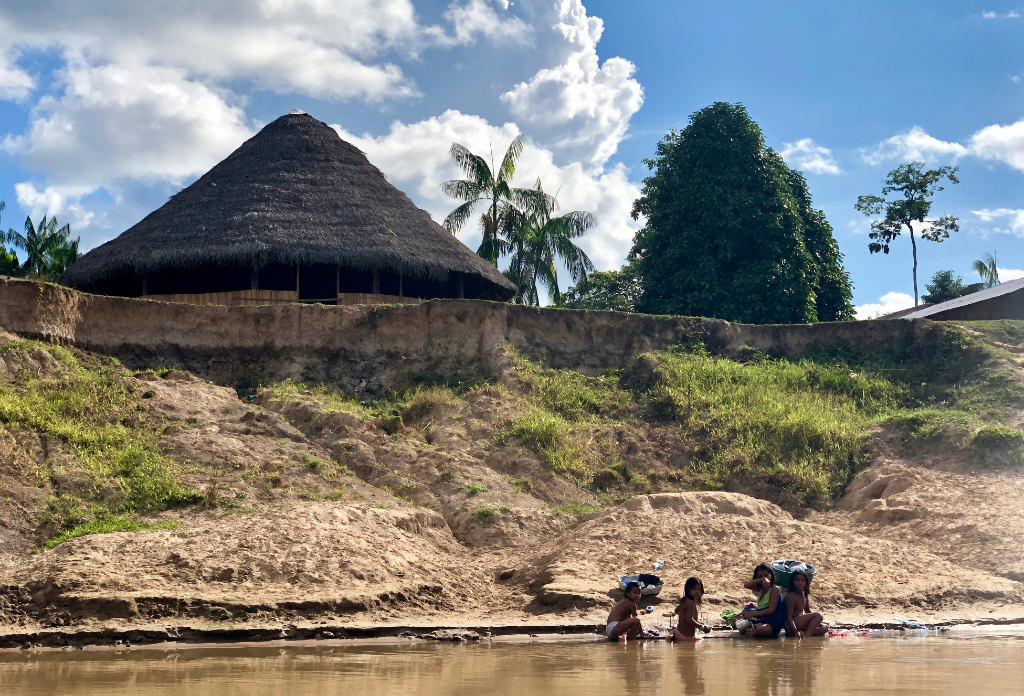 A family from the tribe washing in the Rio Gregorió, a tributary of the Amazon Rainforest in the Acre region. Photograph by John Dyer 