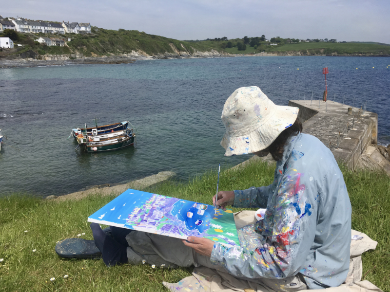 Artist John Dyer at work on his painting 'Summer Days, Portscatho' in the Cornish fishing village of Portscatho in Cornwall.