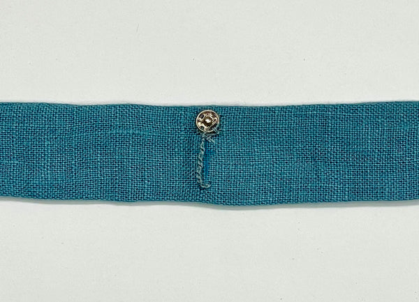 A close-up of the completed thread chain bra keeper on a blue strap.