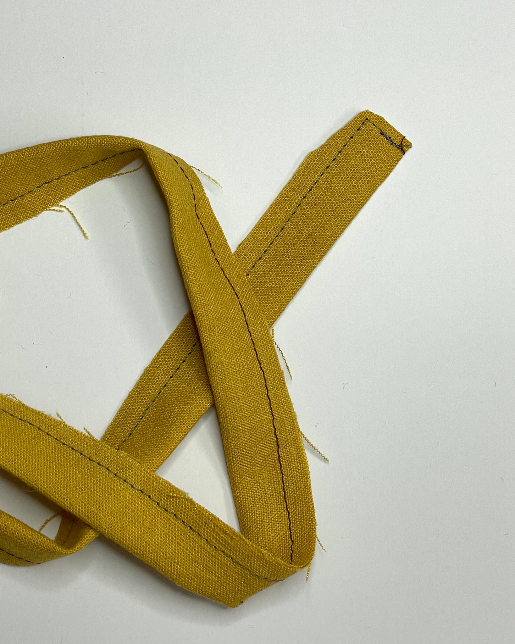 Yellow waist tie with trimmed seam allowance at tip