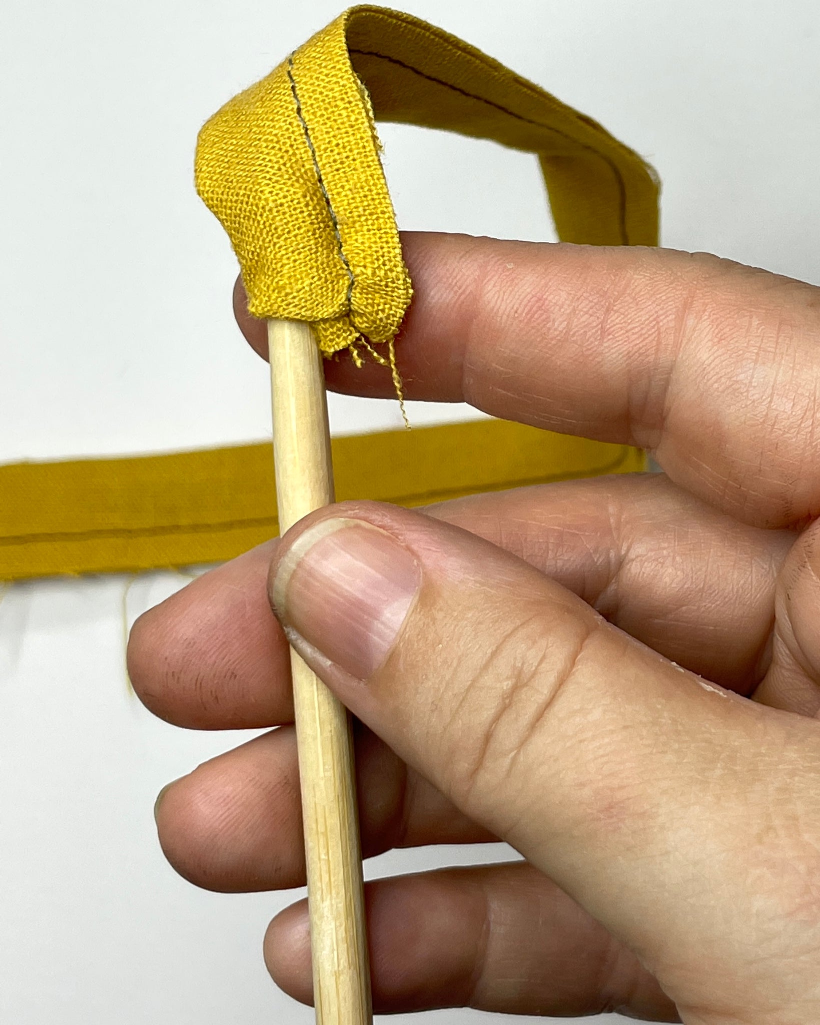 Turning the yellow waist tie right side out.
