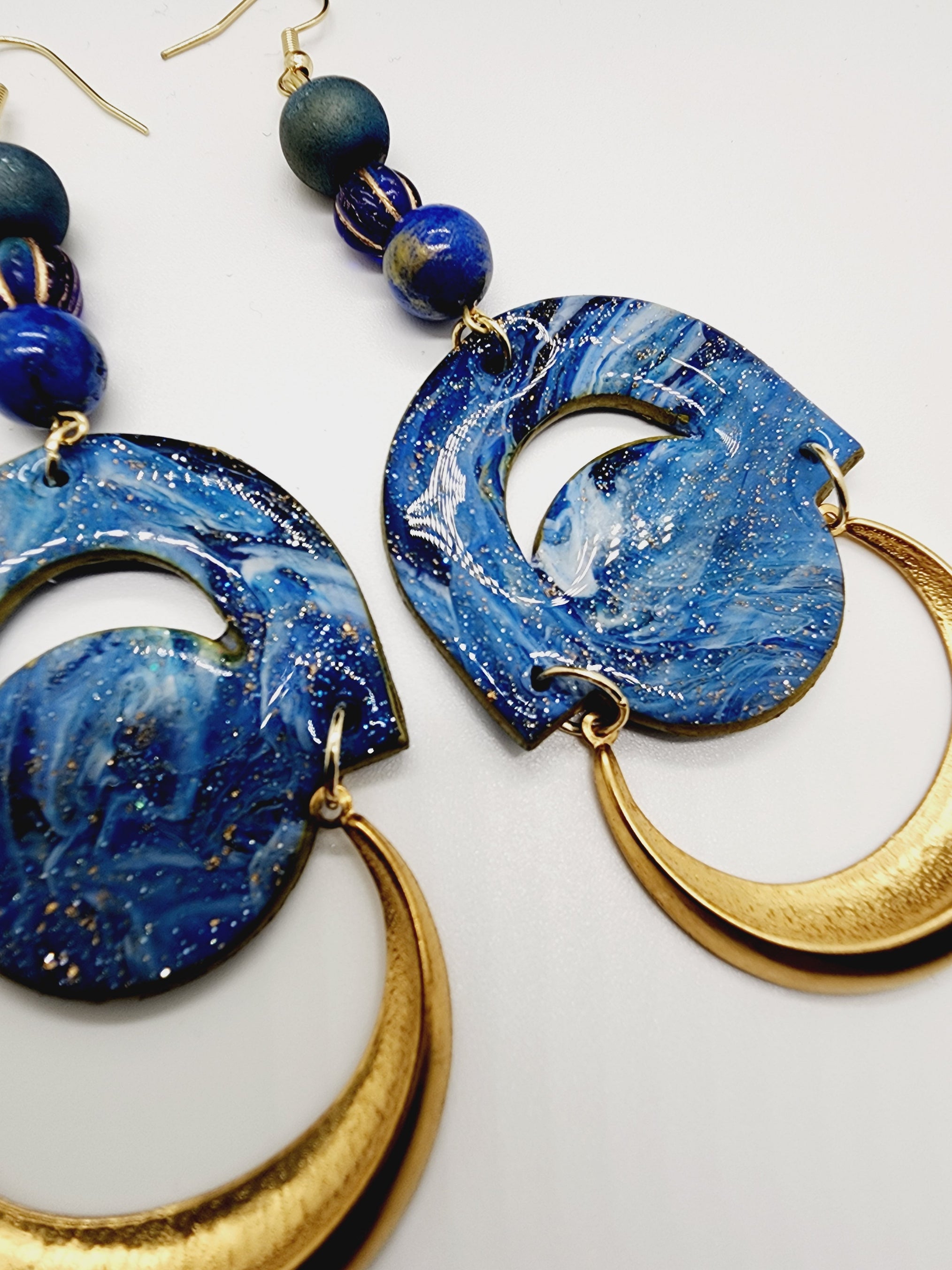 Length: 4.5 inches | Weight: 0.8 ounces   Distinctly You! These handmade earrings are made using blue and gold swirl polymer clay, brass charm, blue speckled beads, and hypoallergenic hooks with back closures. 