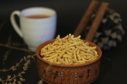 A bowl of Ratlami Sev with a cup of tea in background