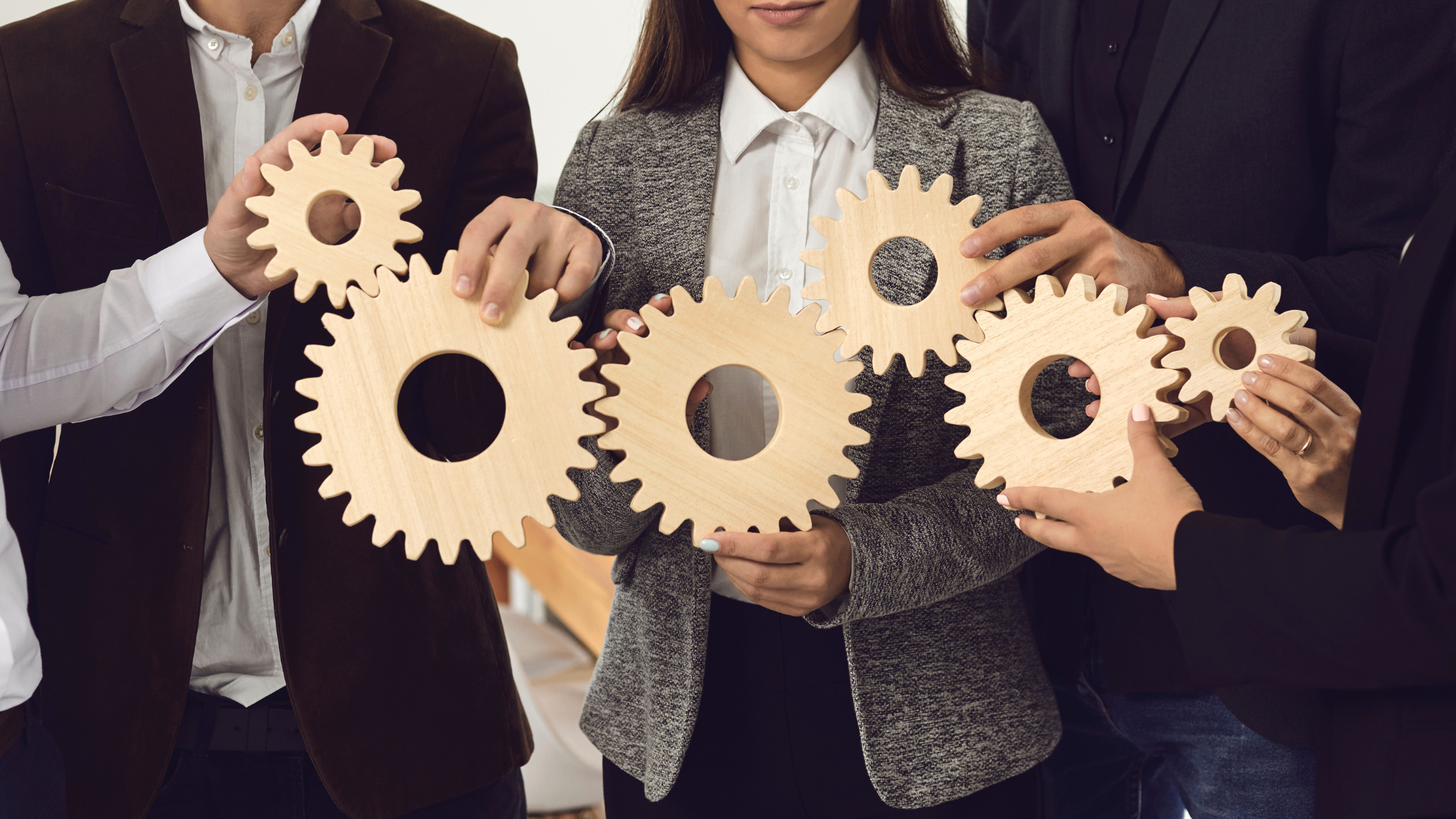 people holding gears forming one big gear working, powerful visual metaphor for collaboration and teamwork