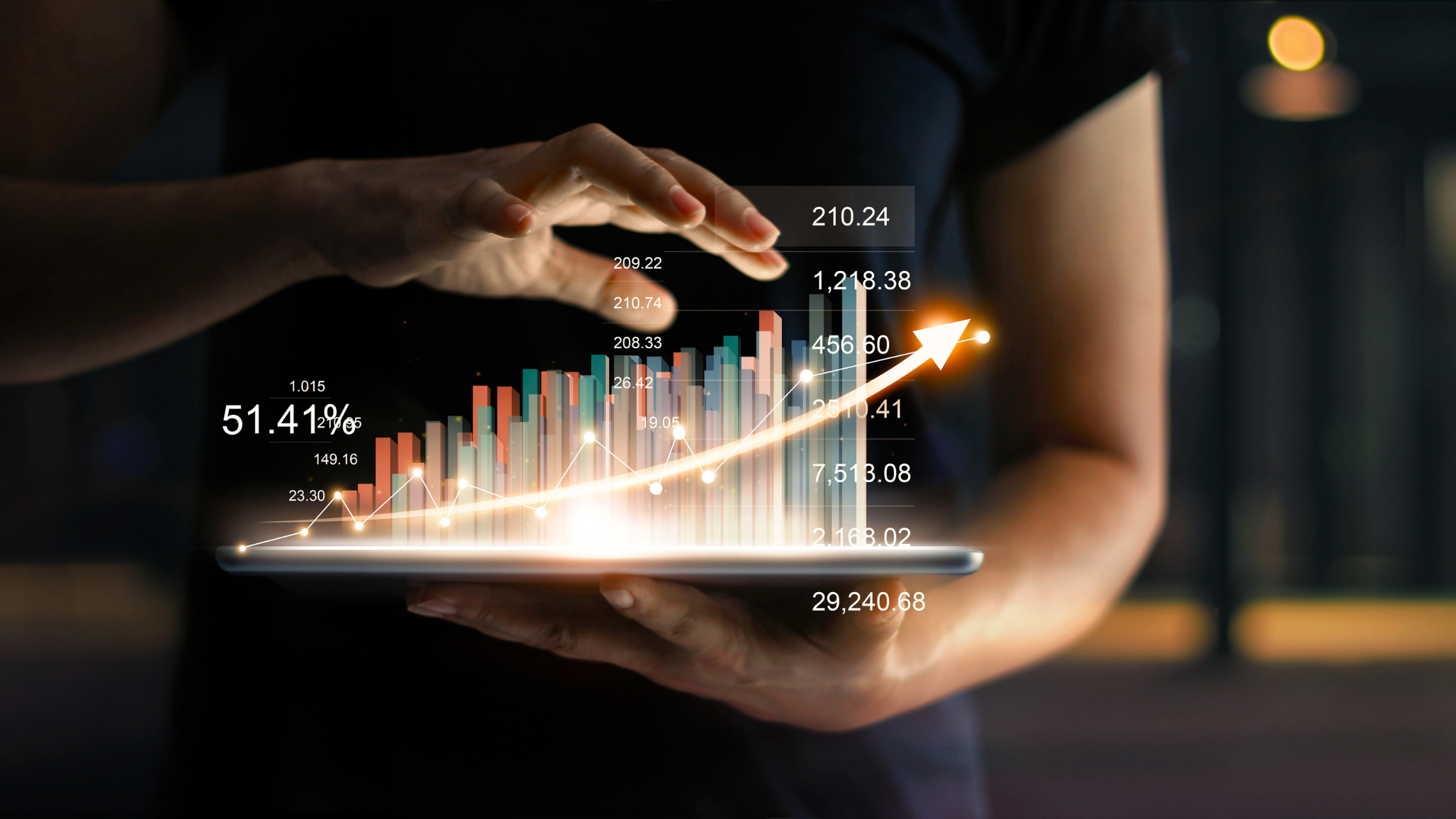 person's hand and numbers and charts coming out of the tablet