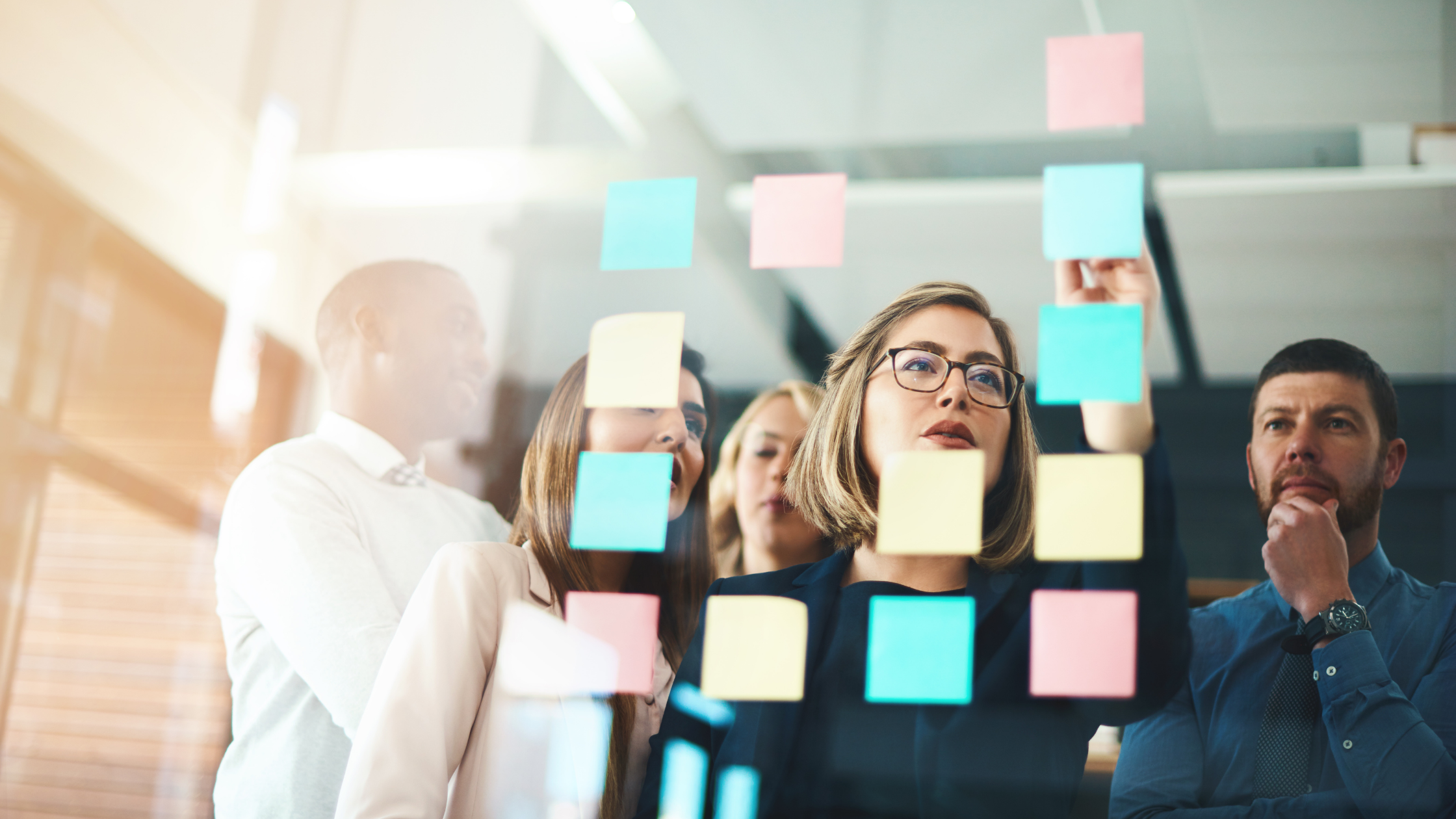 people posting sticky notes in a glass and all looking at them