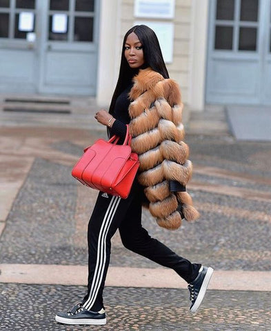 supermodel Naoimi Campbell walking across the street in a fur coat and track pants