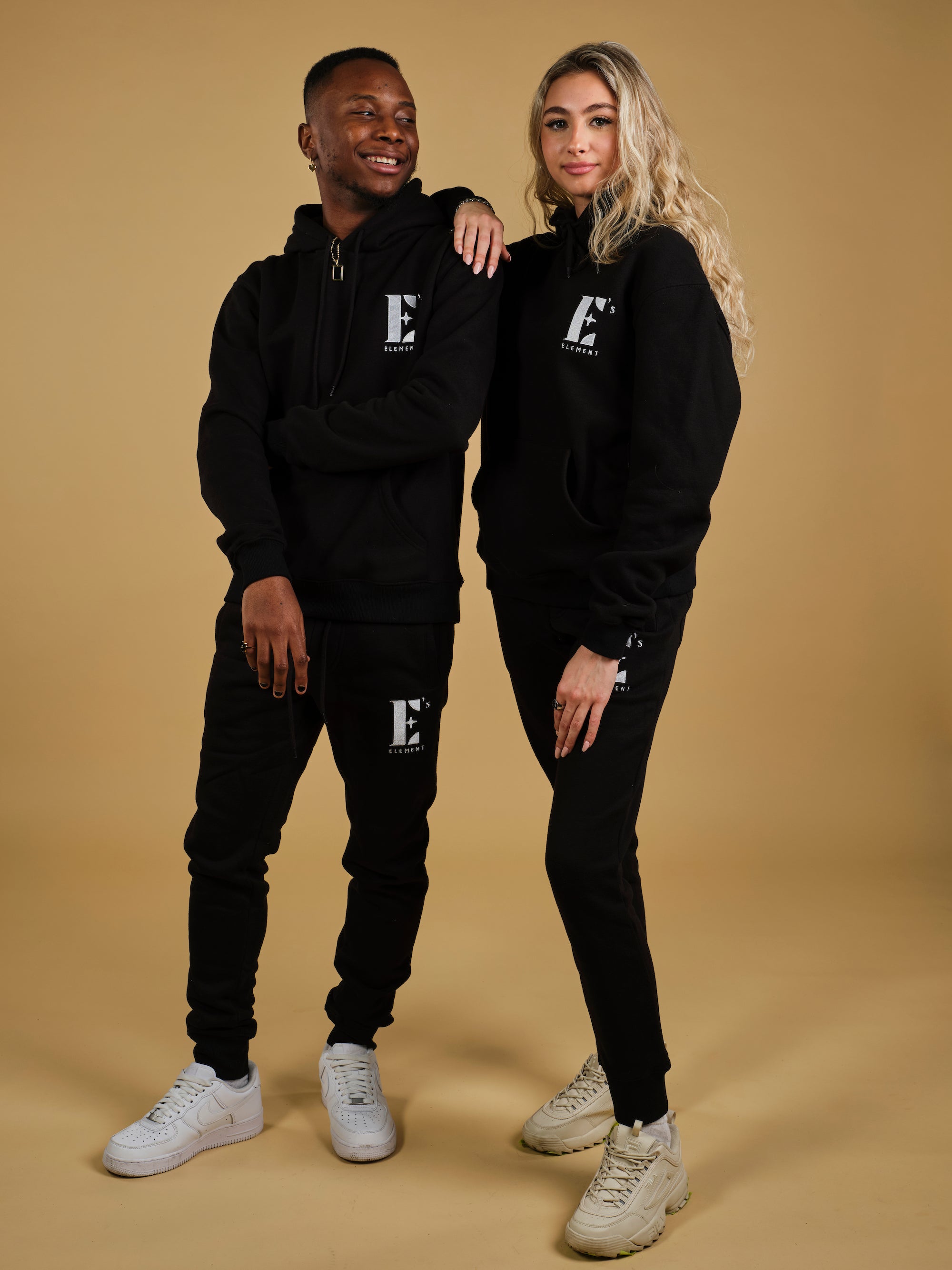 Trinity and Nathan wearing the E’s Element Essential Sweatsuit Set in Smoky Black
