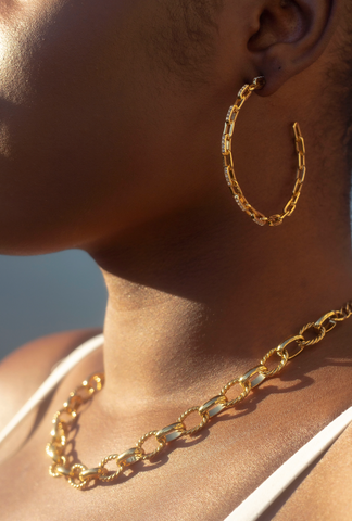 Close up of model's side profile, displaying earring and necklace