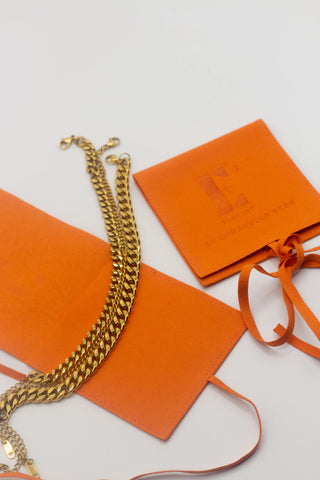 Gold Cuban Link Anklet on grey background and orange E's Element Jewelry Slide Box and Microfiber Pouch | Stainless Steel Jewelry | E's Element