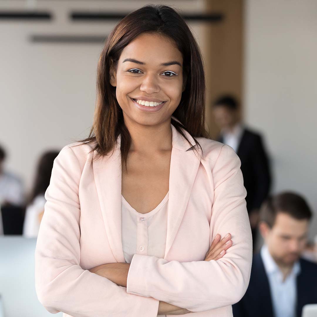 An image of a woman standing in front of employees looking confident.