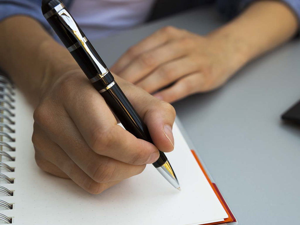  An image of a person writing in a notebook.