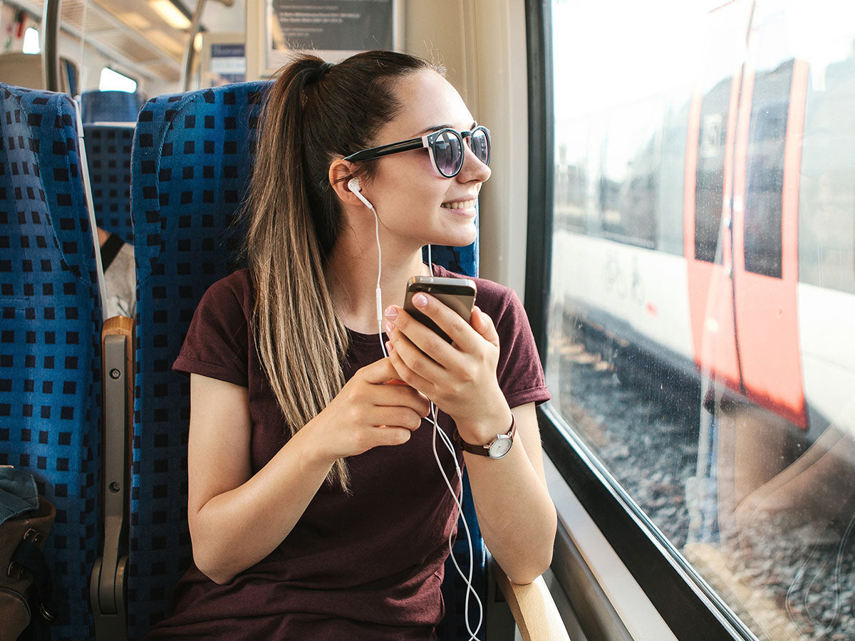 Woman listening to a podcast on the train.