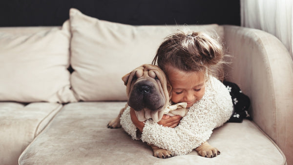 Une enfant fait des câlins à son chien