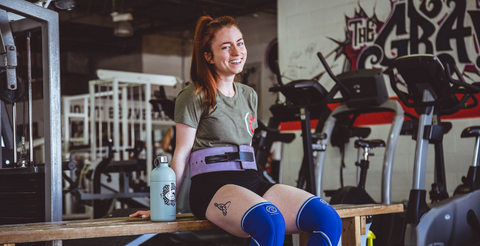 femme qui porte une ceinture à la salle de gym