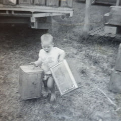 Daryl as a young beekeeper carrying empty honey tins