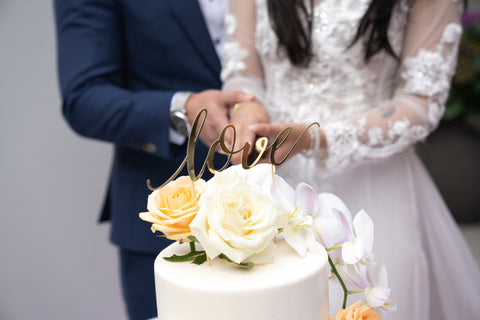 recién casados ​​cortando pastel de bodas