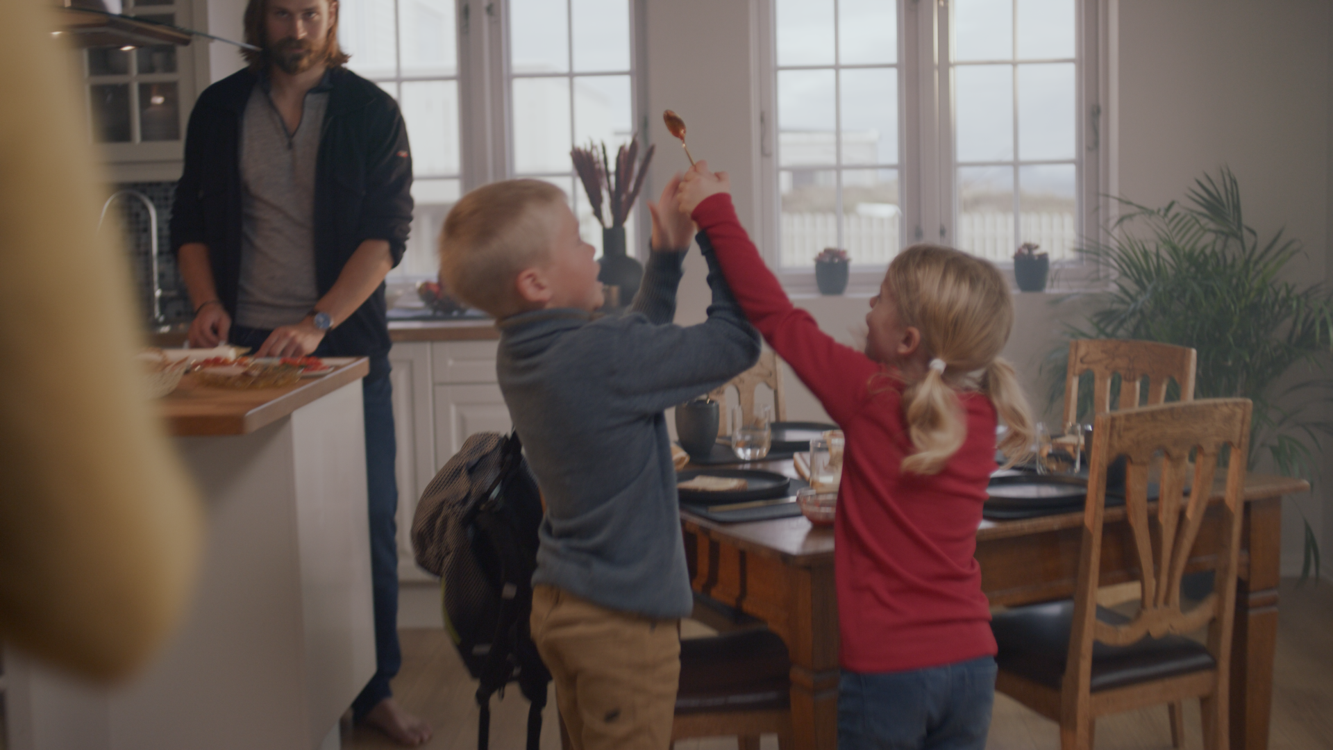 En jente og en gutt krangler ved frokostbordet