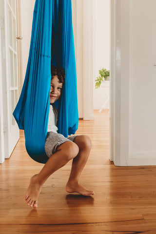 A young boy playing in the Harkla compression sensory swing