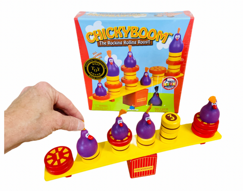Chickyboom game packaging box on white background with hand holding one of the purple chickens on see-saw