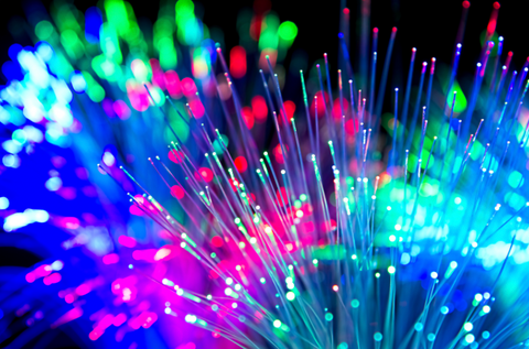 Brightly coloured fibre optic lights in pink blue and green in dark room