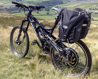 Electric bike with baby carrier in a grassy field.