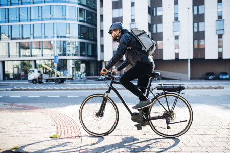 Businessman riding an electric commuter bike to work.